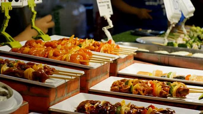 亚洲街头美食。在木串上完成烤肉串，柜台上有蔬菜