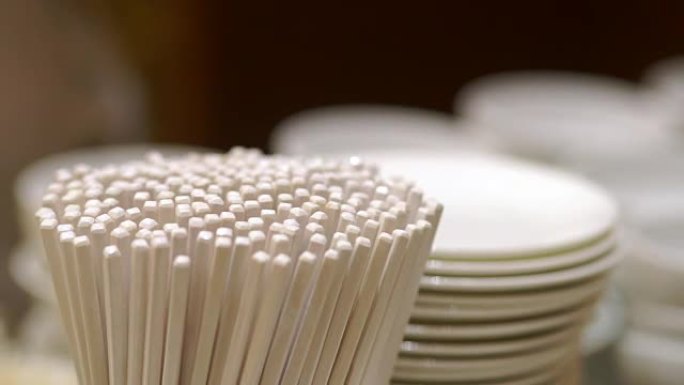 餐具存放有许多筷子、白碗和盘子。