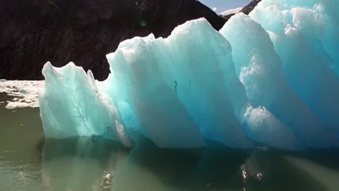 在阿拉斯加水上太平洋上的山的背景上移动浮冰。