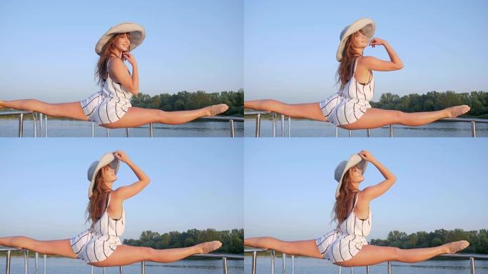夏天在海岸河上的运动形式的笑脸女孩体操运动员戴上帽子，背景是蓝天