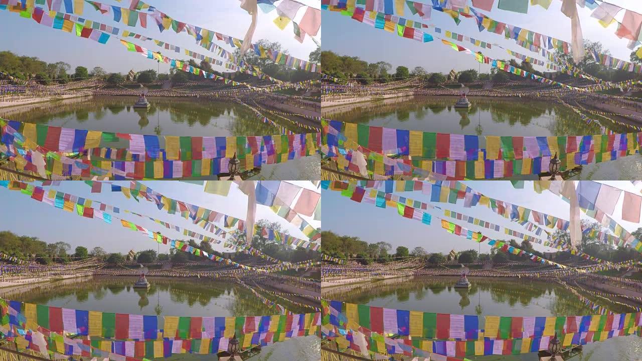 印度马哈菩提寺荷花池塘背景上的彩色旗帜