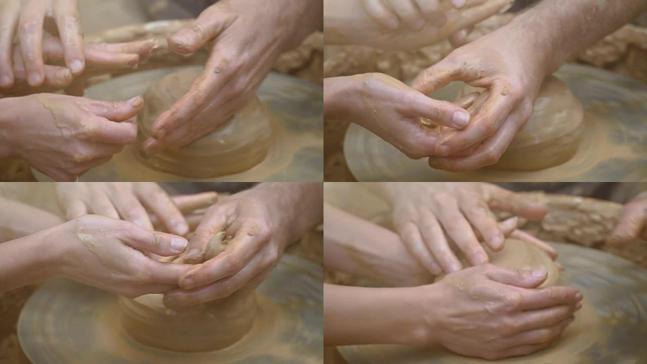 两只交织在一起的手在陶工的轮子上形成一锅粘土。