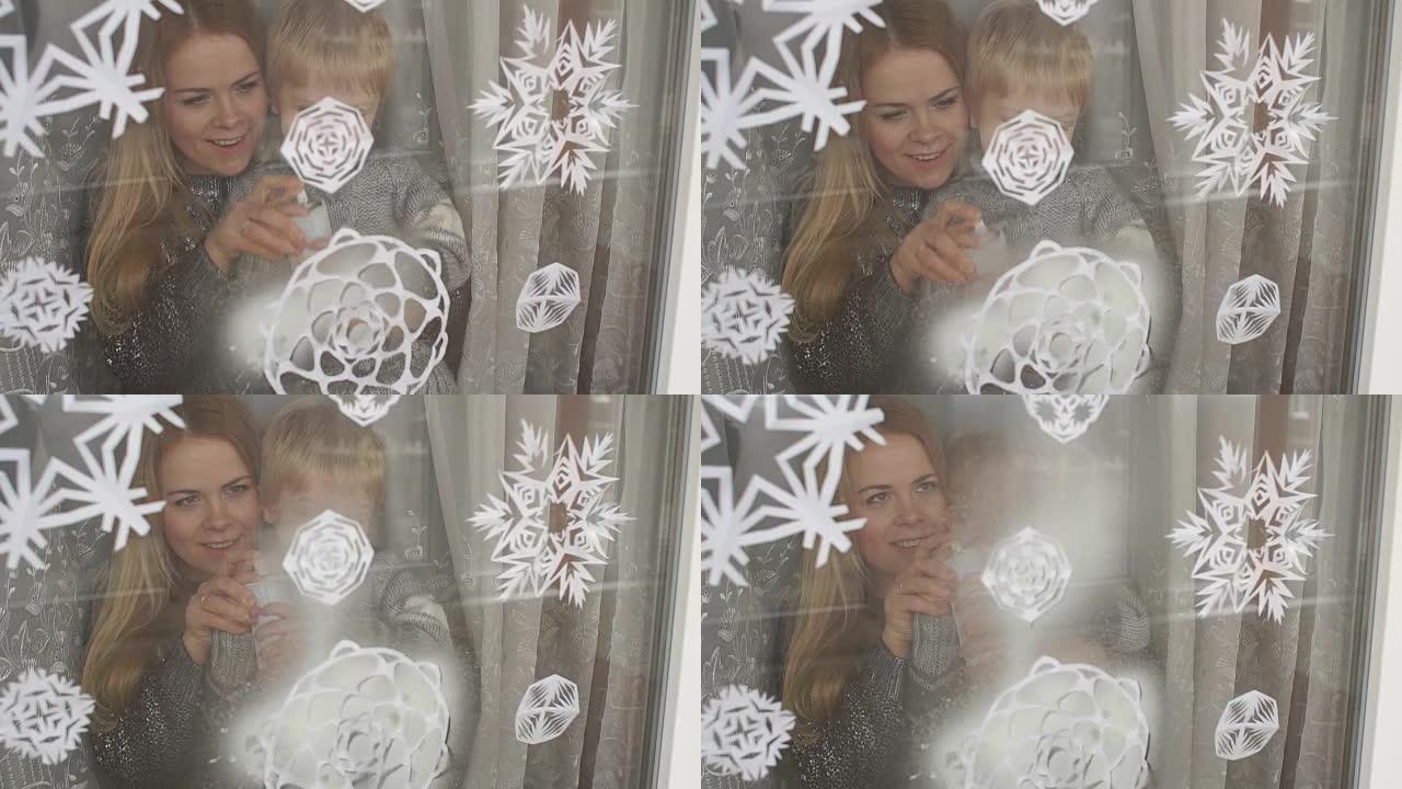 妈妈和儿子用人造雪装饰窗户。
