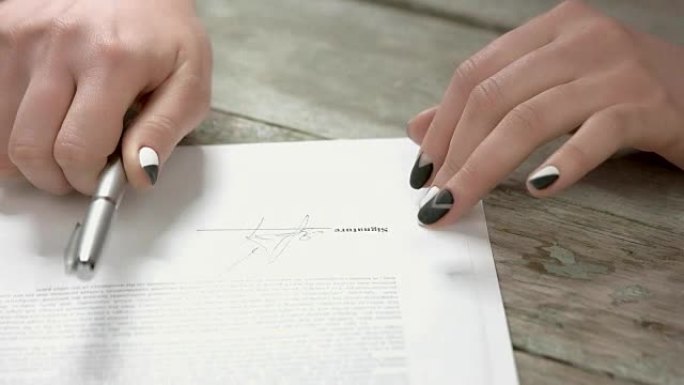 修剪整齐的手在文件上签名。