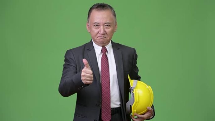 成熟的日本商人作为工程师竖起大拇指