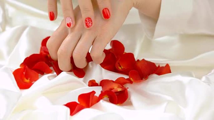白丝上的雌性手和玫瑰花瓣。