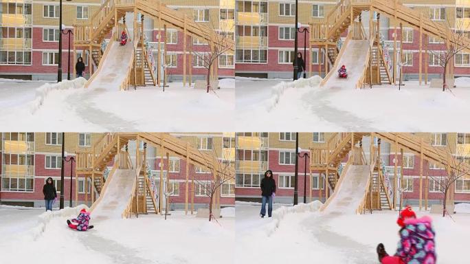 Child and mother riding slides at playground