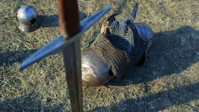 盔甲背景下的中世纪剑在地面上