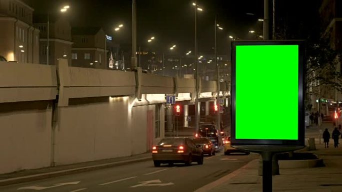 繁忙街道上有绿屏的广告牌。