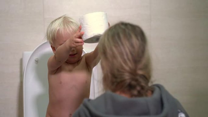 可爱的男婴和妈妈在玩卫生纸