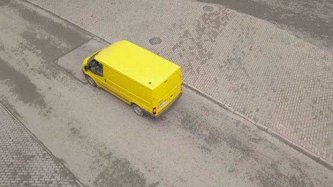 黄色小巴沿柏油路行驶。黄色客货车在公路上行驶