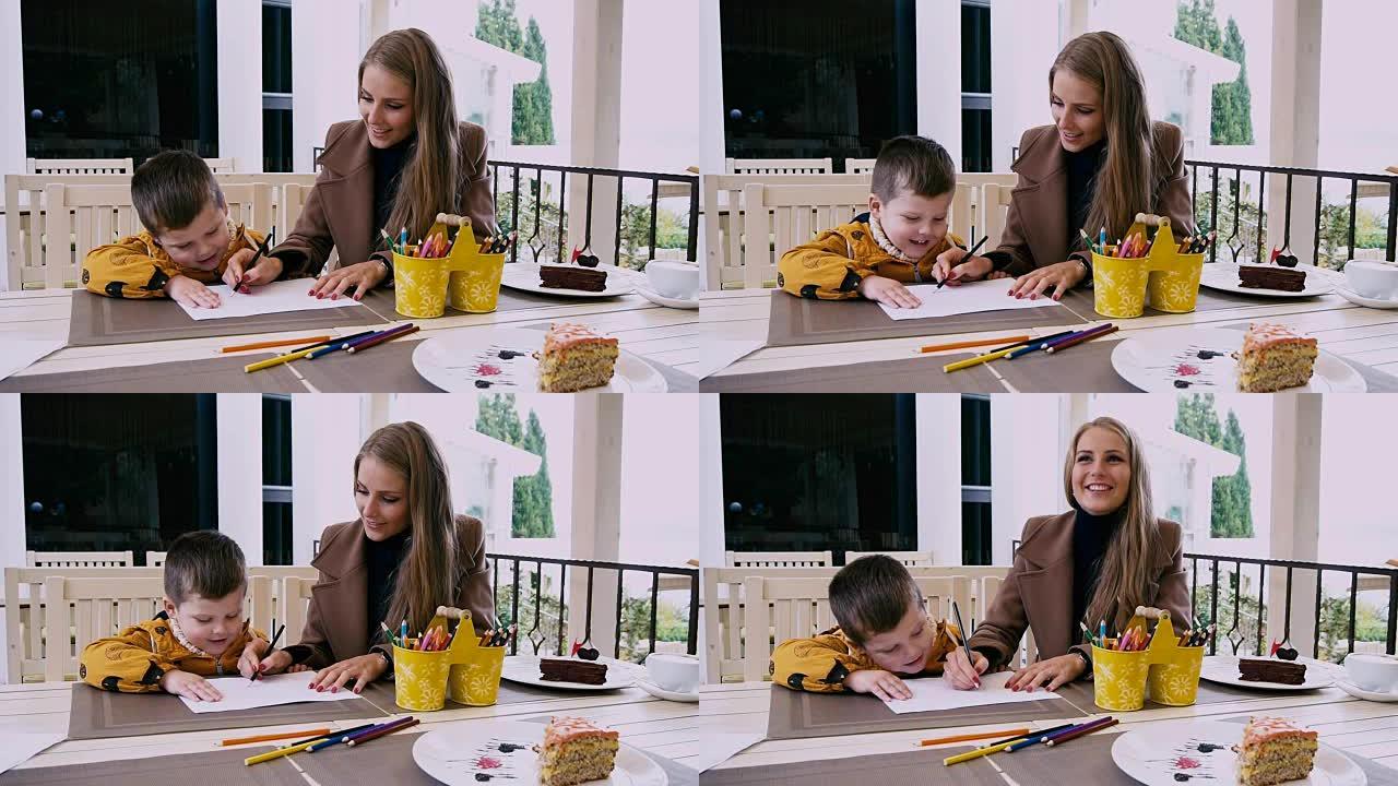 妈妈和小男孩在餐桌上用蜡笔画画
