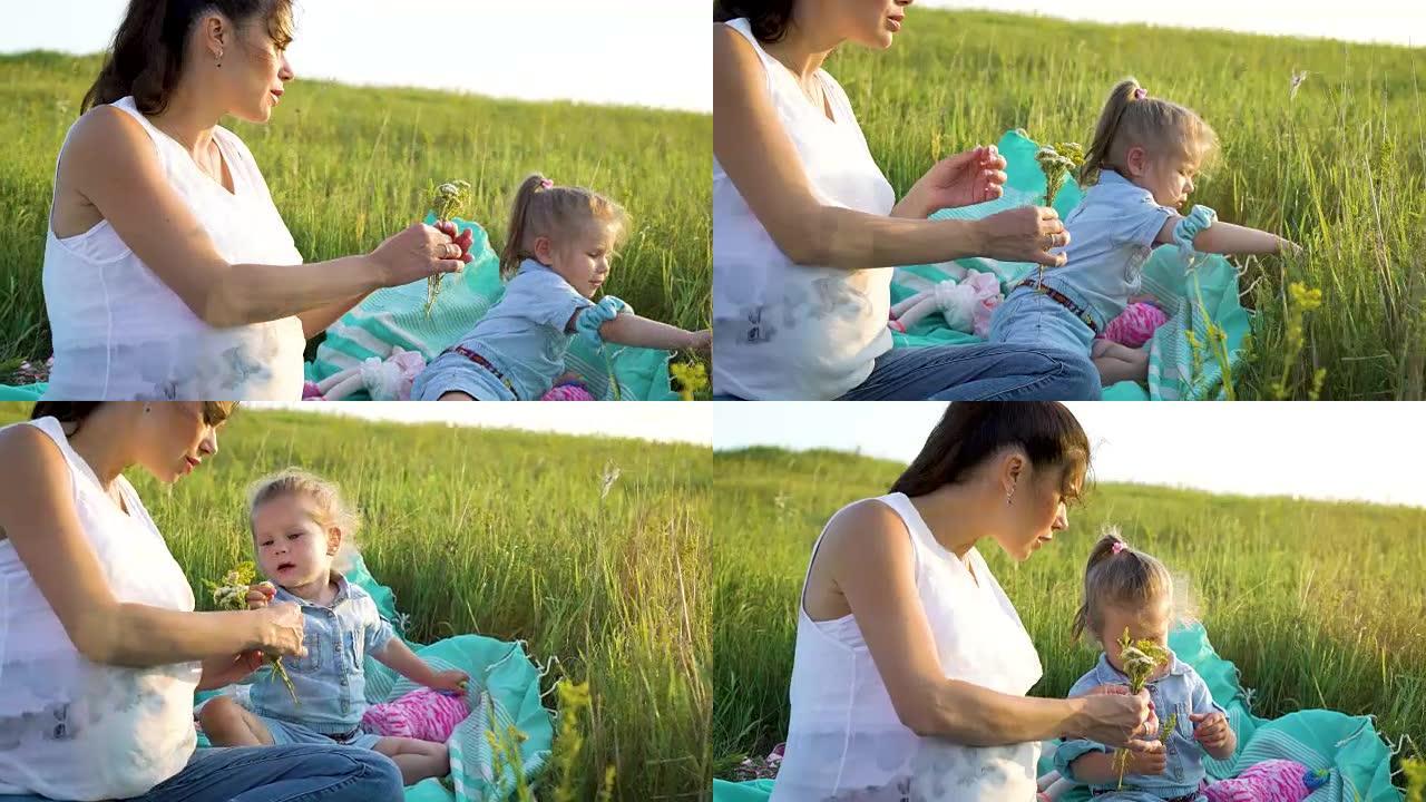 迷人的幸福母女分享爱在毯子上的草地上一起看花