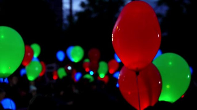 爱情盛宴的概念。黑色背景下飞行的发光彩色氦气发光气球，适合情人节、新年和圣诞节，红色心形气球形状