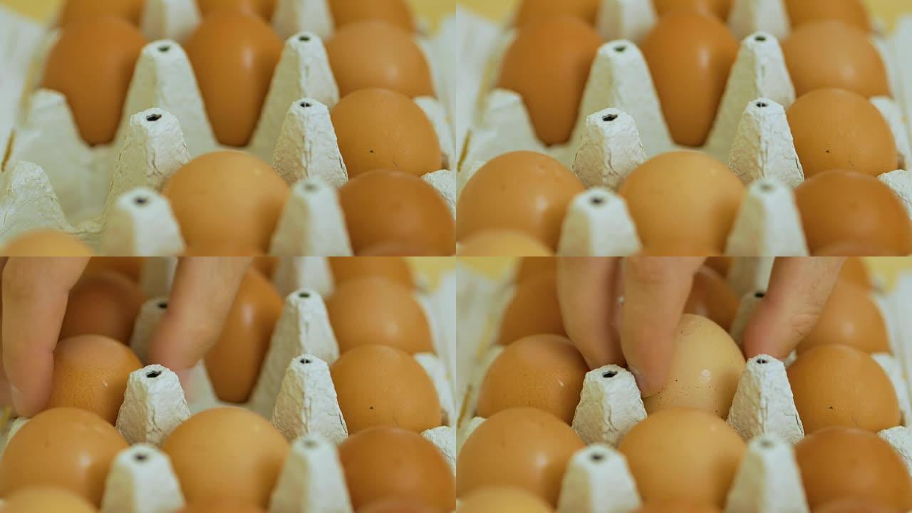 用手折叠包装中的鸡蛋。关闭灰色鸡蛋纸箱，人们将鸡蛋从纸箱中取出。