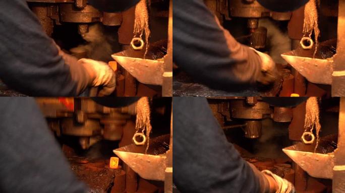 铁匠工人用钳子在锻压机下换红色铁锭