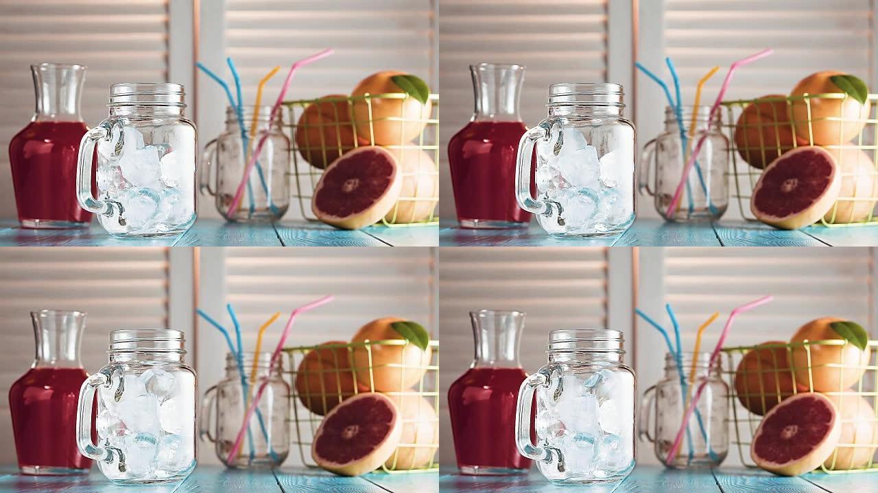 冰块掉进空的梅森罐子里，慢动作。百叶窗对面的质朴蓝色木桌上的新鲜葡萄柚和葡萄柚汁罐。