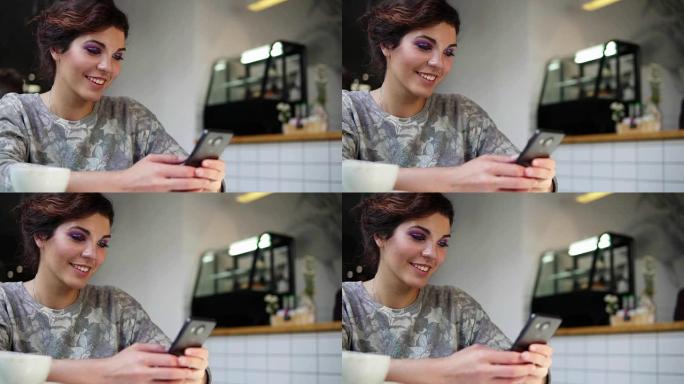 美丽的年轻女性在咖啡馆使用手机的侧视图。微笑。女人在咖啡馆里使用智能手机上的应用程序喝咖啡，用手机发