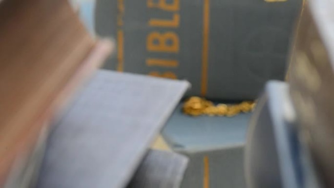 书架上圣经上的金色十字架，放大，用滑块拍摄