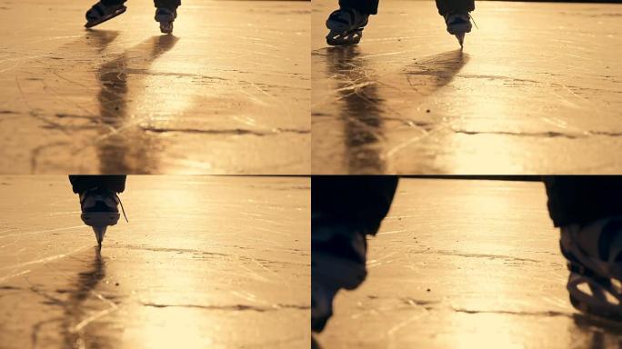 冬天在阳光下在湖上冰上滑冰的男孩的剪影。慢动作
