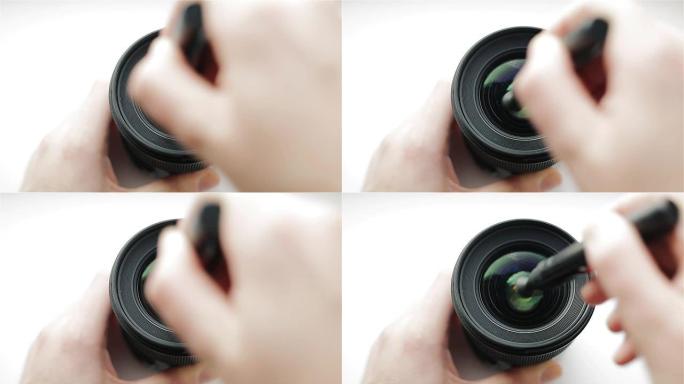 专业摄影师或视频摄影师用笔或刷子清洁剂清洁摄影镜头的前玻璃。光学专业清洁系统
