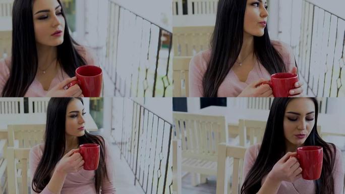 黑发女孩喝红色杯子里的热茶