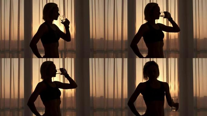 阳光明媚的早晨，运动女人在家喝水。