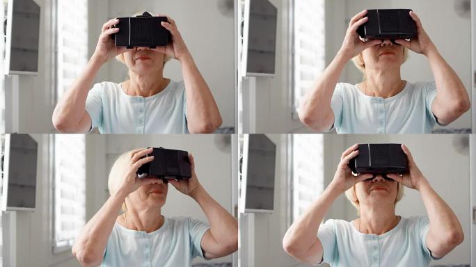 漂亮的金发高级女子在白色使用VR 360眼镜在家里。活跃的现代老年人