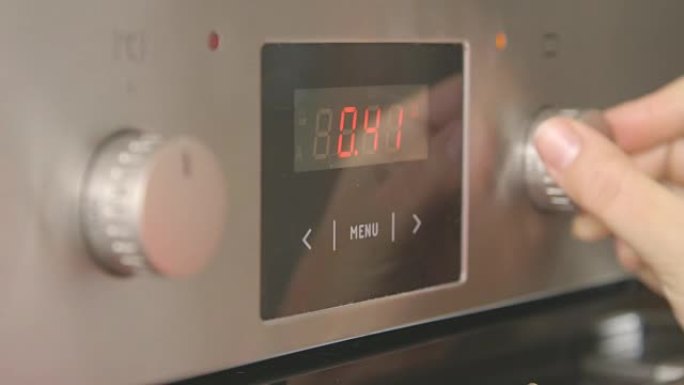 女人在厨房用电烤箱烘烤设置烘烤模式和温度