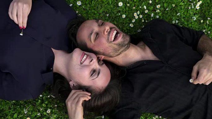 两个恋人躺在草地上深情地聊天