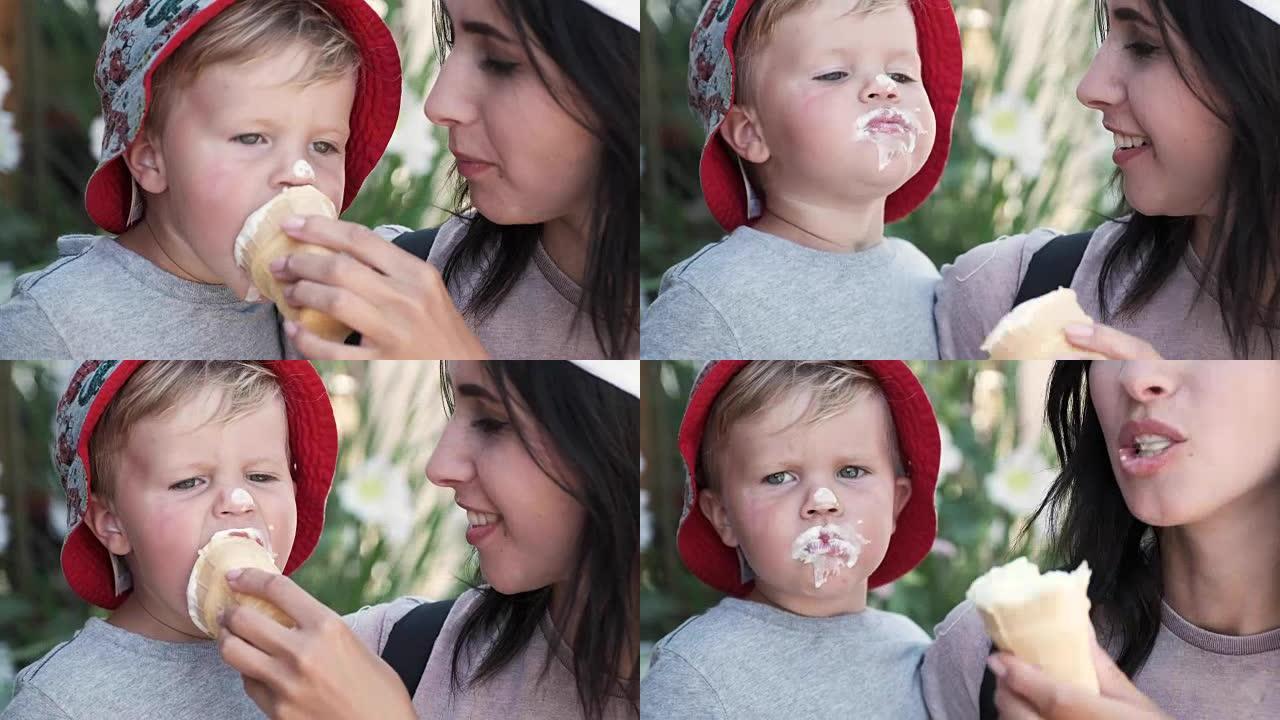 一位慈爱的母亲给她的孩子吃冰淇淋。一个小男孩吃得开心，精神振奋，脸脏