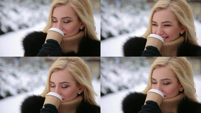 穿毛皮大衣的女孩在冬季公园喝咖啡。