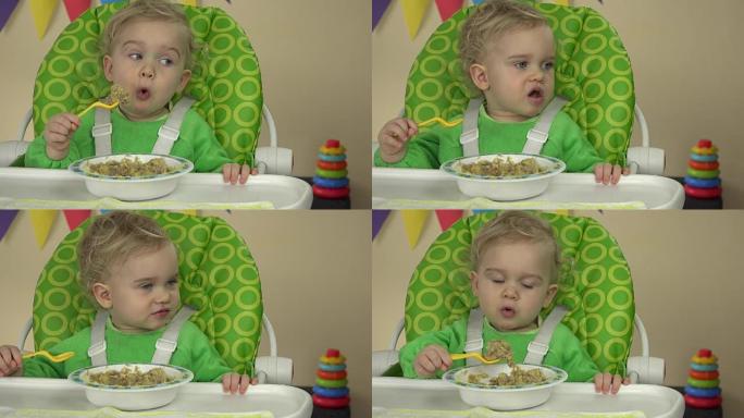 小女孩练习用勺子吃稀粥坐在婴儿椅上。全高清