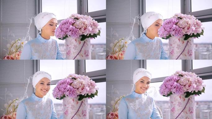 美丽的穆斯林新娘穿着漂亮的婚纱，闻着花