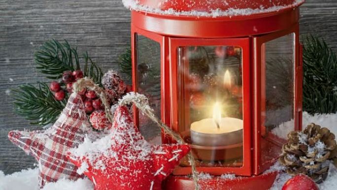 Cinemagraph of snow falling with candle in red lan