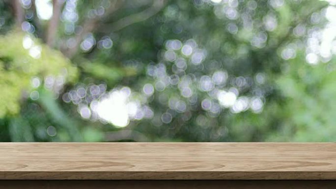 公园bokeh灯光背景的空木桌面，带模糊绿树，产品或设计展示的背景模板，食品支架模型