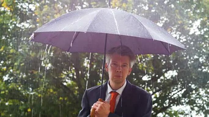 商人在雨中躲在雨伞下