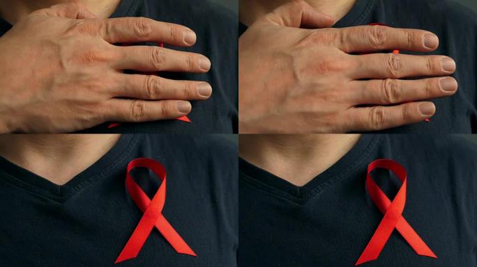 一名男子在衬衫上系上红色意识丝带。艾滋病毒/艾滋病概念。