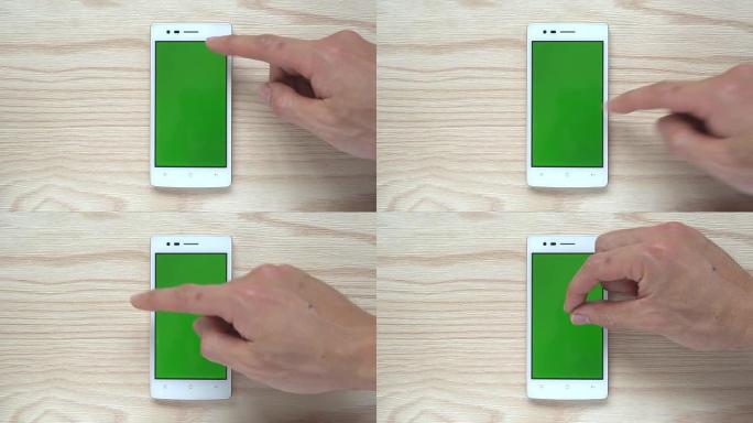 木质背景上的人类滑动智能手机或手机绿屏