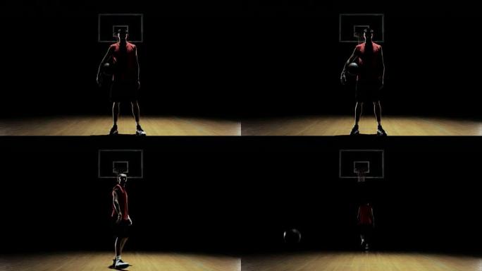 一名篮球运动员运球，然后捡起球，盯着镜头。