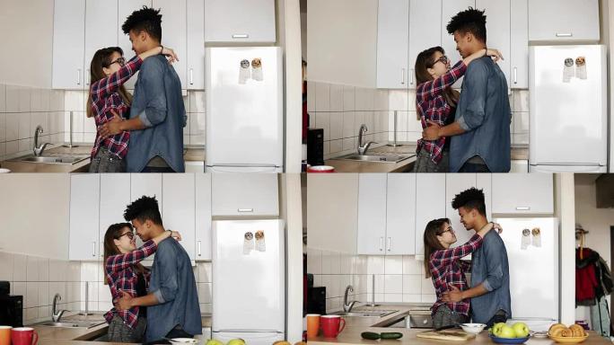 可爱的浪漫情侣在舒适舒适的厨房跳舞，享受一起生活，青春。承诺，关系目标。