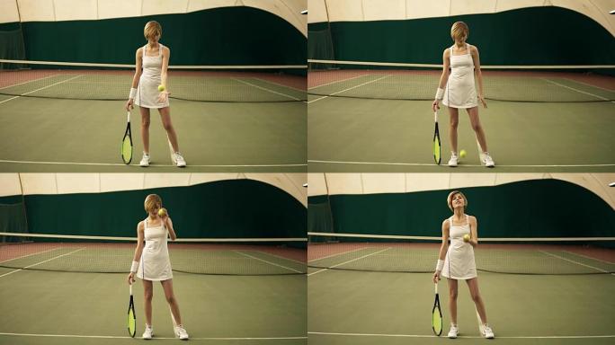 一位年轻迷人的运动女性穿着白色运动服，穿着金色短发，在有盖网球场玩球的全身尺寸肖像镜头