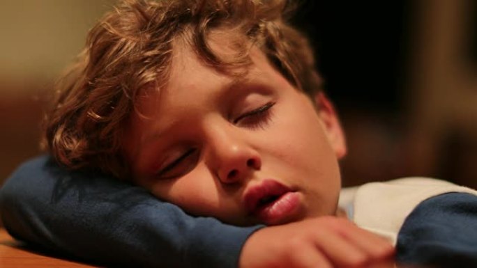 可爱的孩子在深度睡眠瘫痪状态下睡着了。一整天的活动让小男孩做梦筋疲力尽。孩子在桌子上休息和睡觉