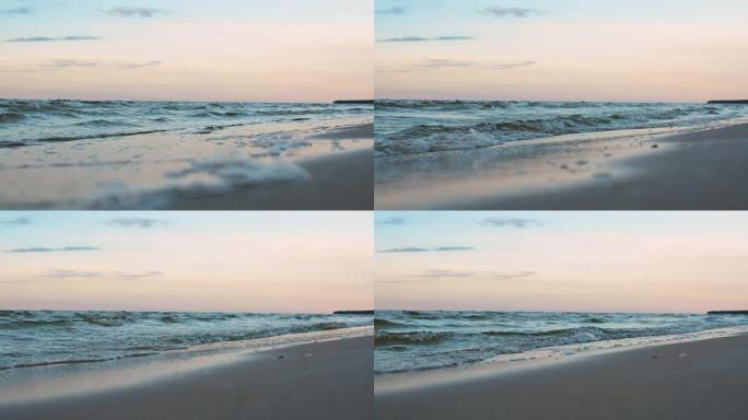 微浪在暮色日落蓝色的傍晚灯光下缓慢滚入海滩