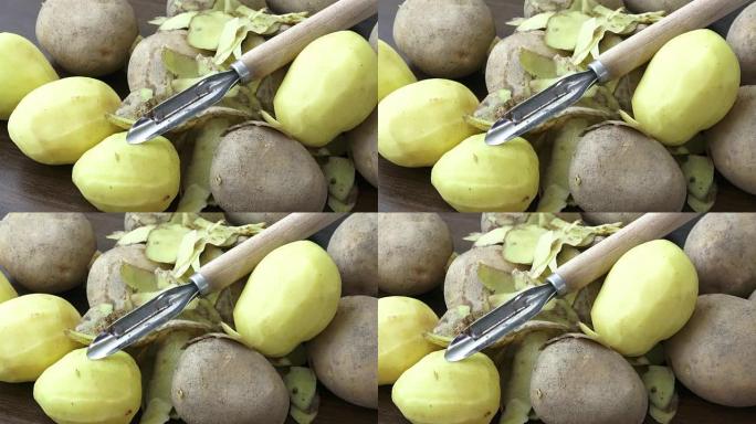 Raw potatoes and knife on a wooden background