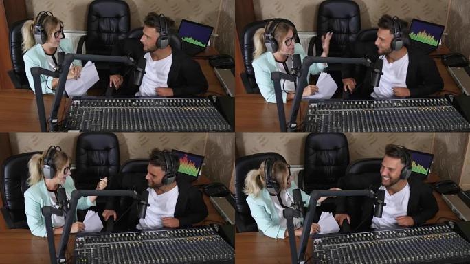美丽的广播主持人戴着耳机的男人和女人在录音棚里对着麦克风说话