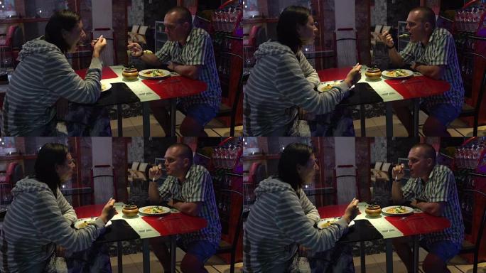 一男一女坐在餐馆里吃炖菜