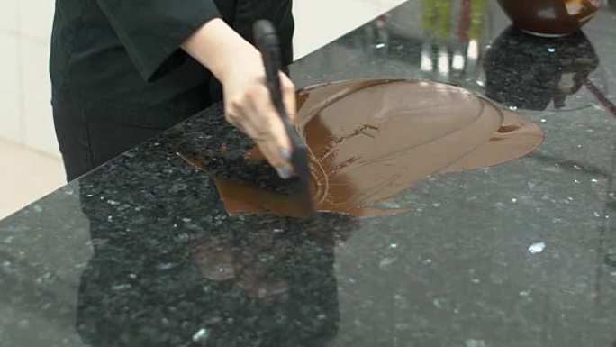餐桌上的糖果用刮刀对巧克力进行回火