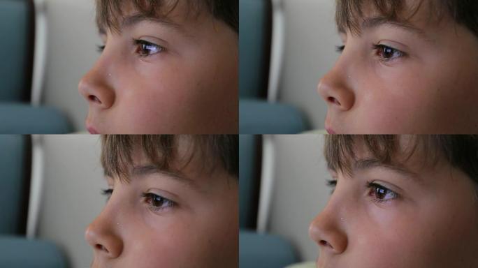 儿童眼睛在屏幕上的特写镜头。在平板电脑上播放的小男孩眼睛的特写镜头