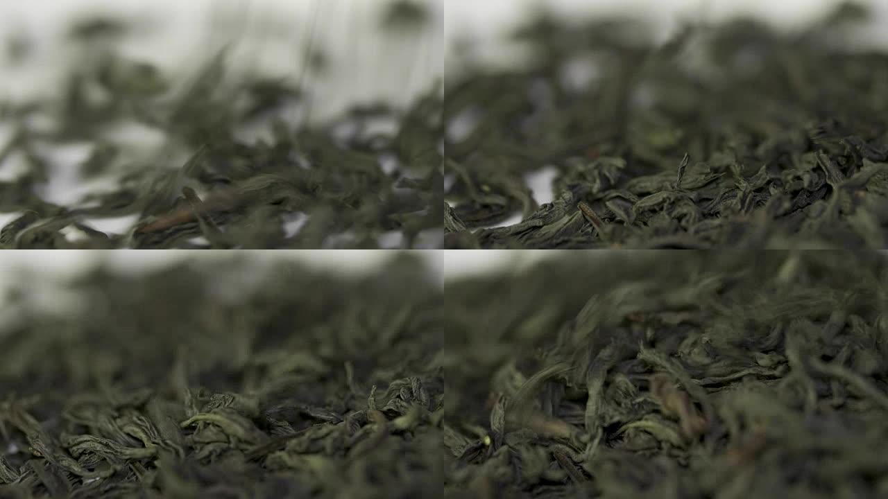 白色背景上落下的干绿茶叶。白色背景上的茶滴
